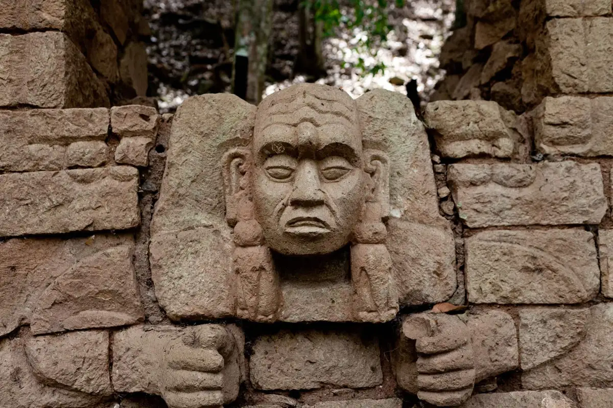 Rostro de piedra tallado en un muro de templo de Copán, visto en las excursiones desde San Pedro Sula