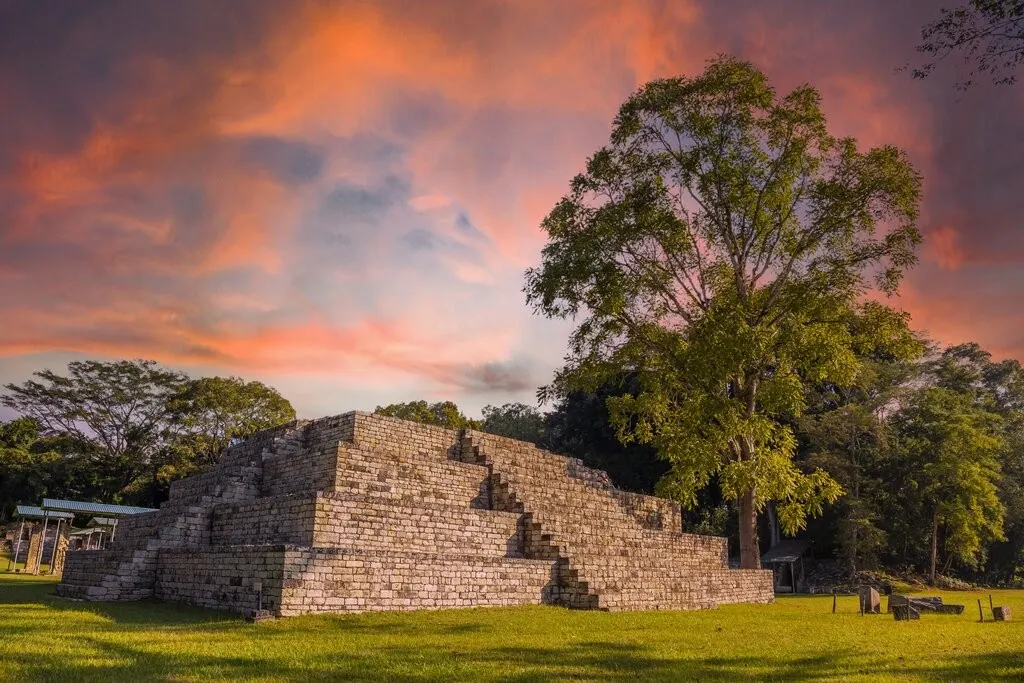 Pirámide maya escalonada en Copán bajo un cielo de atardecer, el yacimiento de las excursiones desde San Pedro Sula