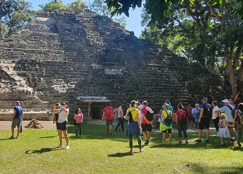 Visitantes al pie de un templo escalonado en las excursiones a las ruinas mayas desde San Pedro Sula hasta Copán